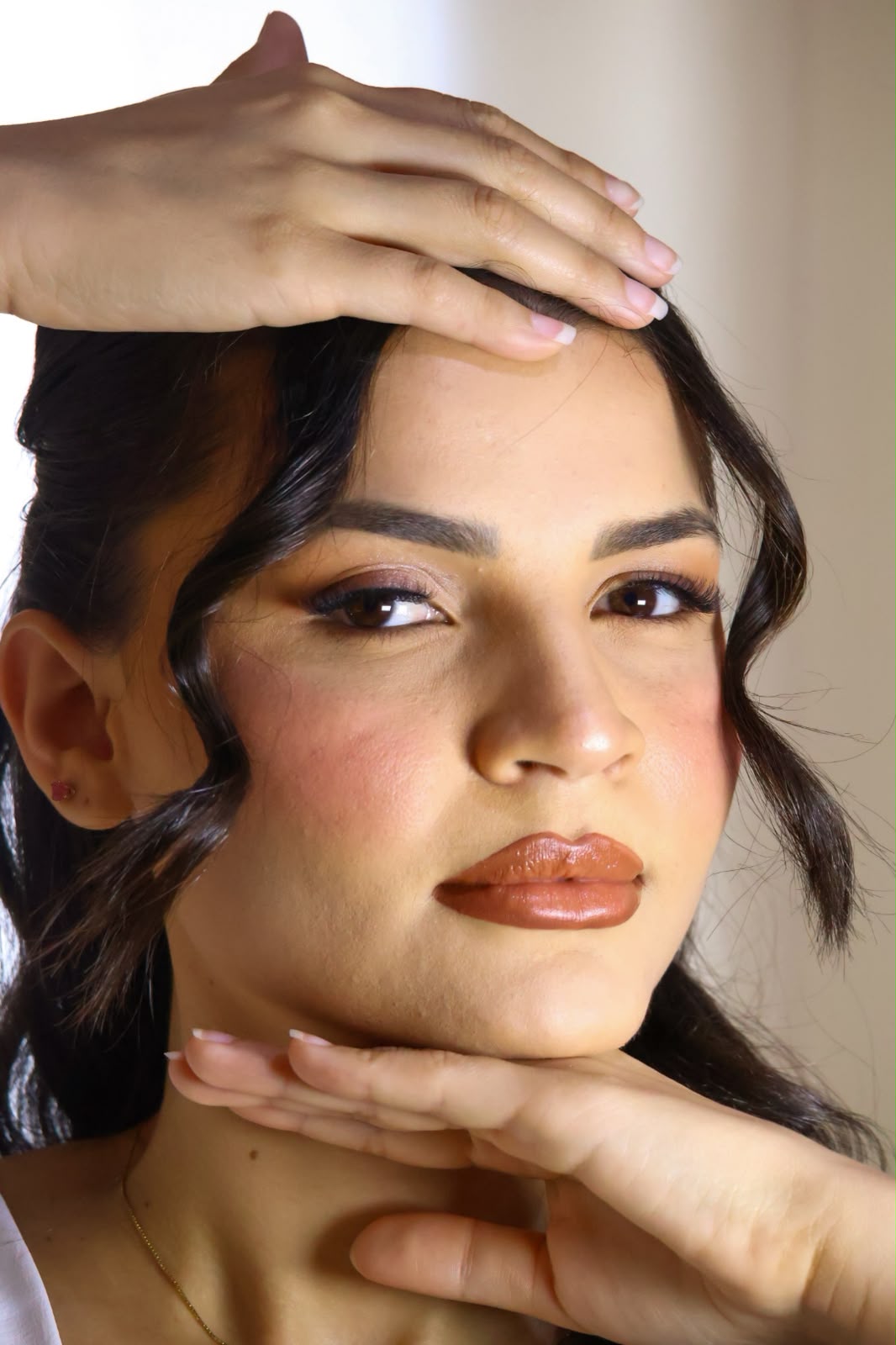 Close da maquiagem de noiva com pele iluminada, olhos esfumados e boca acetinada