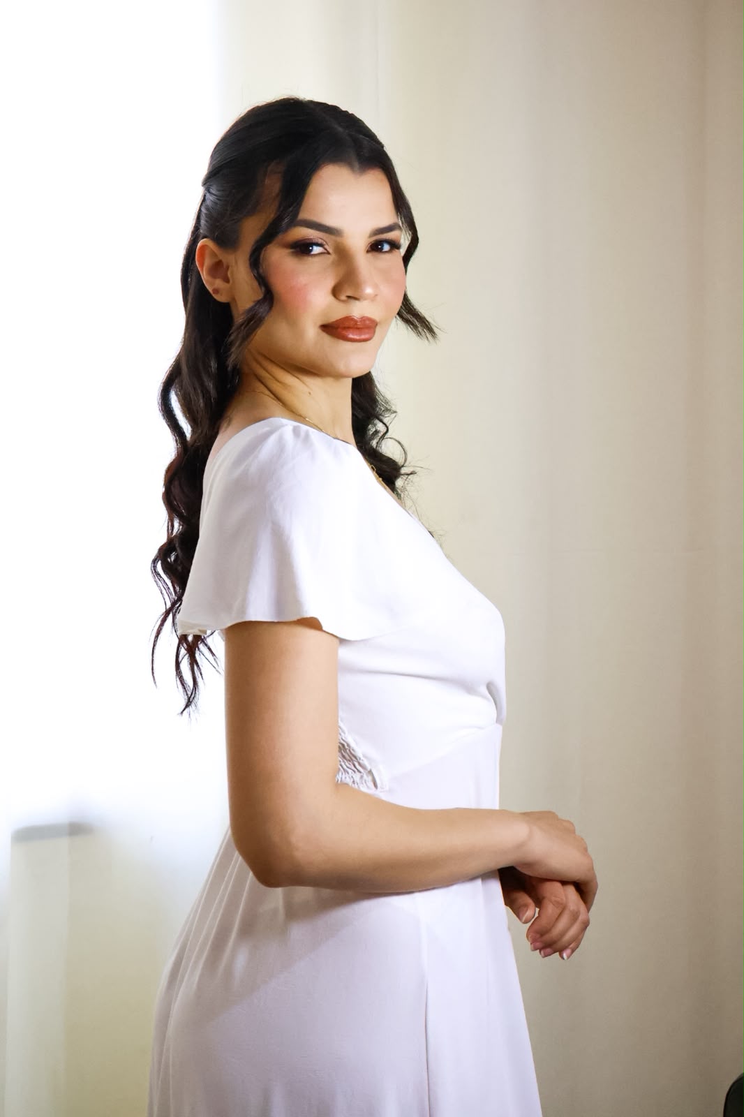 Noiva de perfil com maquiagem elegante e acabamento impecável para fotografia